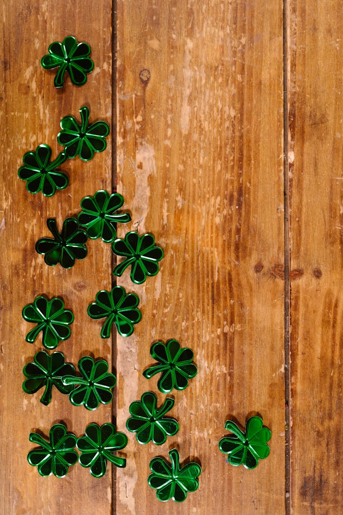 Green shamrock decorations on wooden surface for St. Patricks Day.
